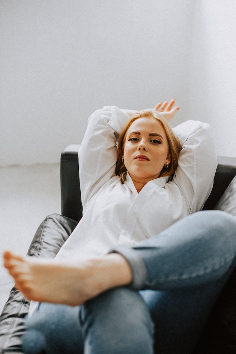 a woman sitting on a couch with her feet up